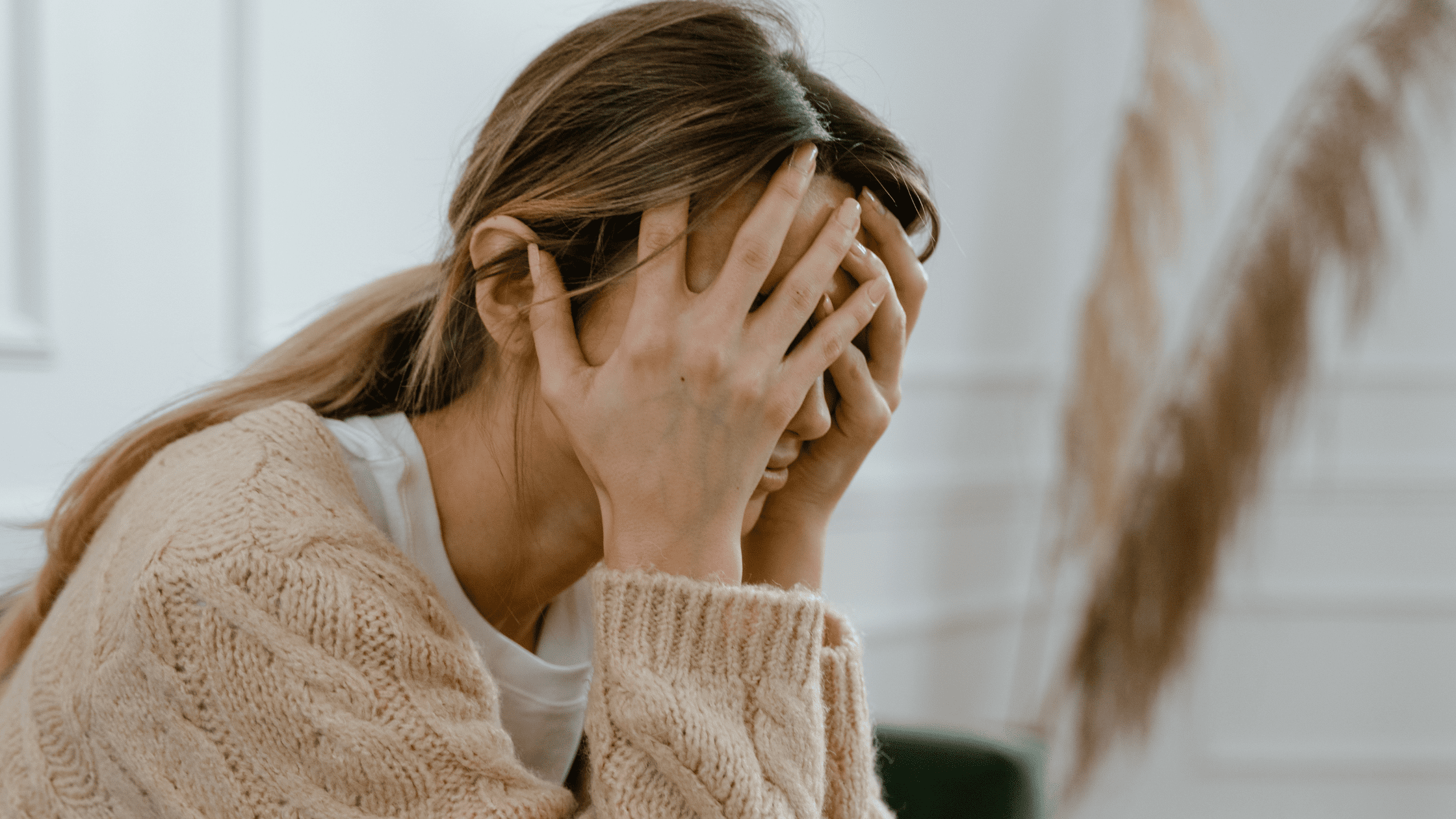 Young lady covering face with hands after failing USMLE Step 1