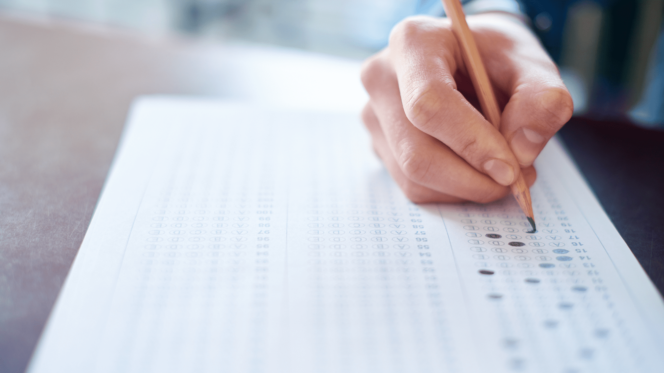 A medical school students filling in a multiple choice exam bubble sheet while taking a UWSA practice test.