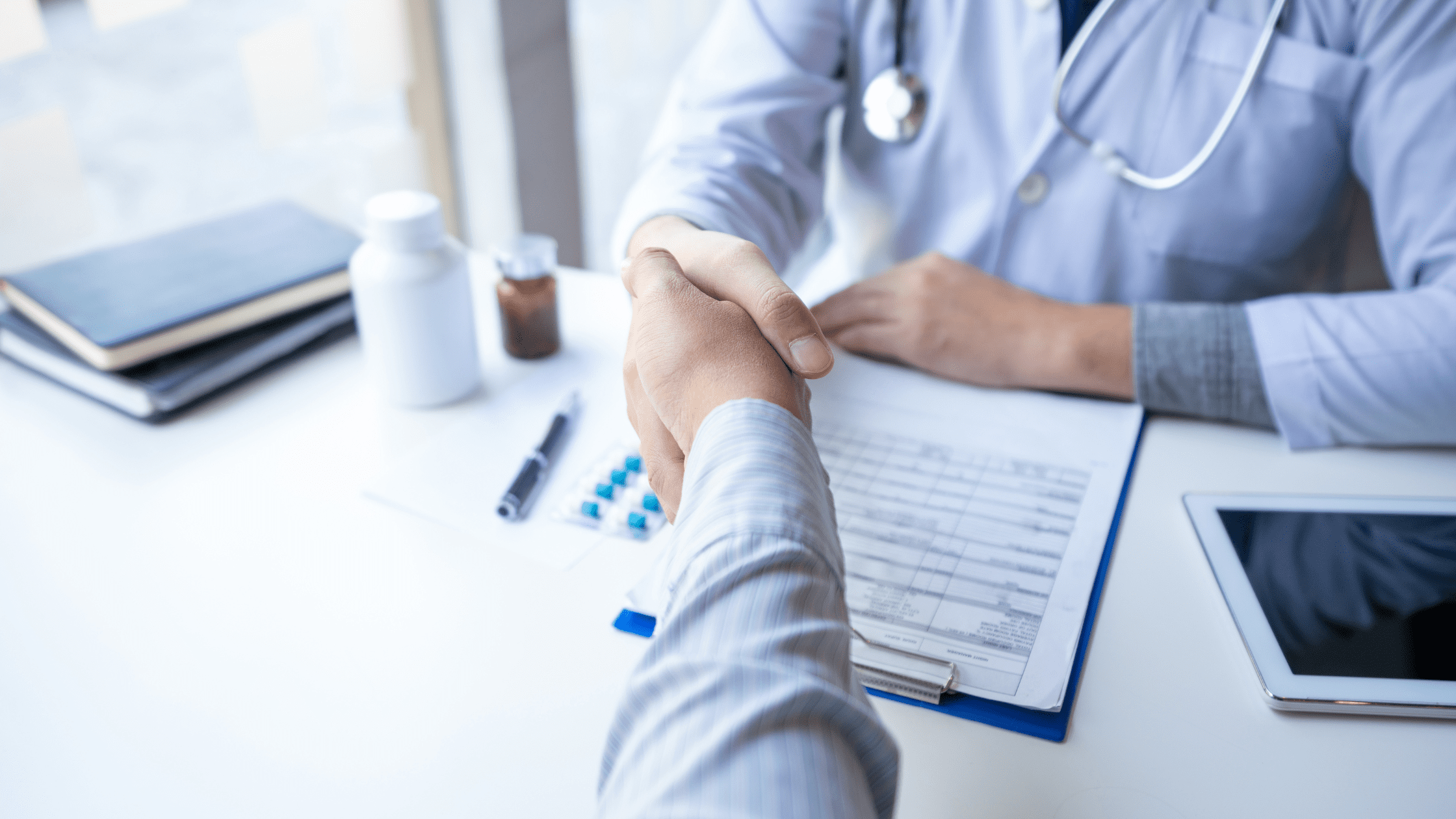 A doctor shaking hands with a prospective resident during a residency interview.
